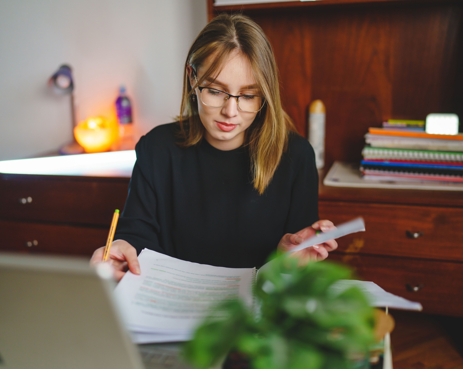 A young woman writing in a notebook.