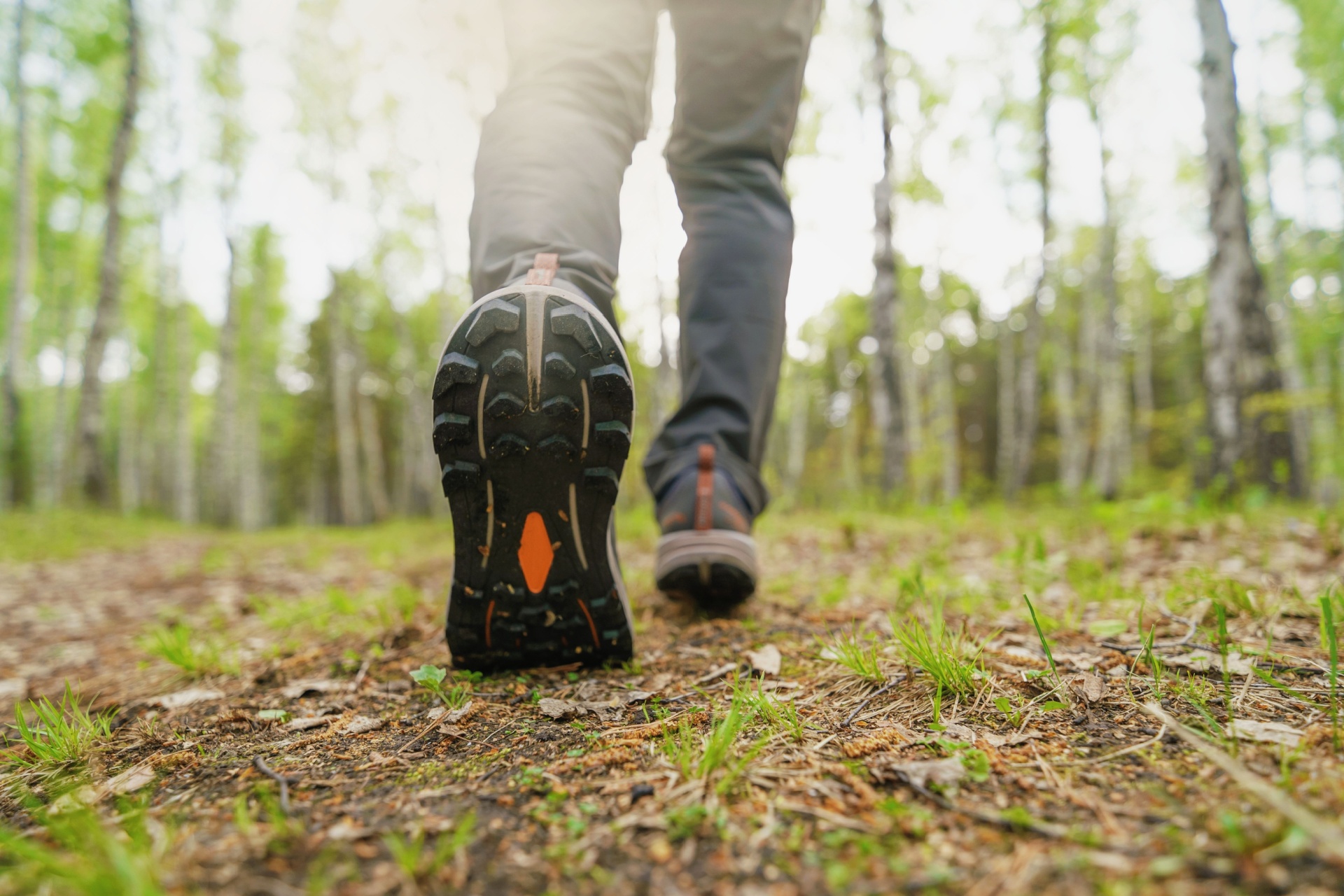 A close-up of the boots of a person walking in the woods.