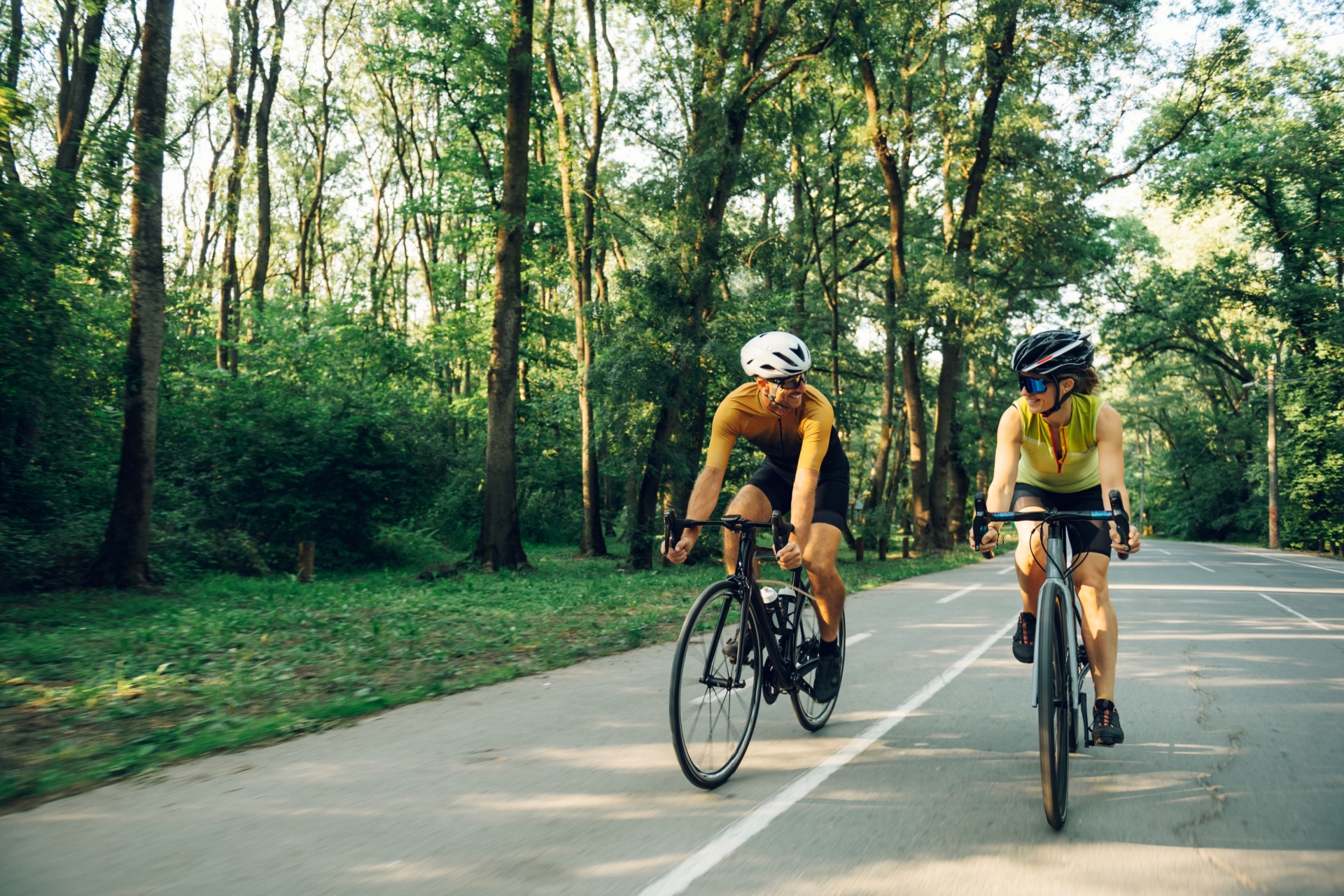 A couple cycling together on a road.