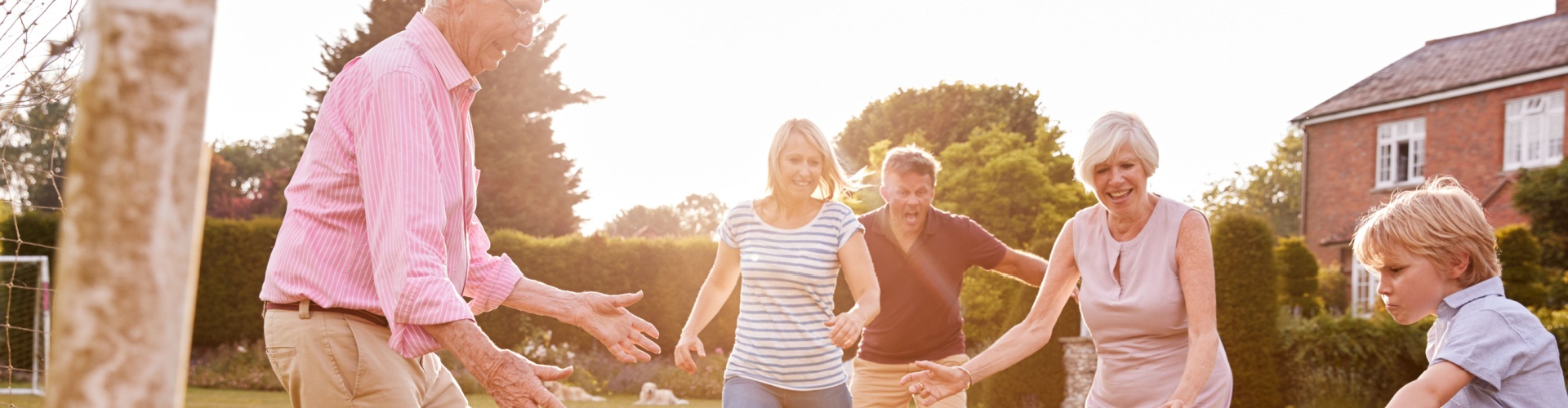 A family playing football in a garden.