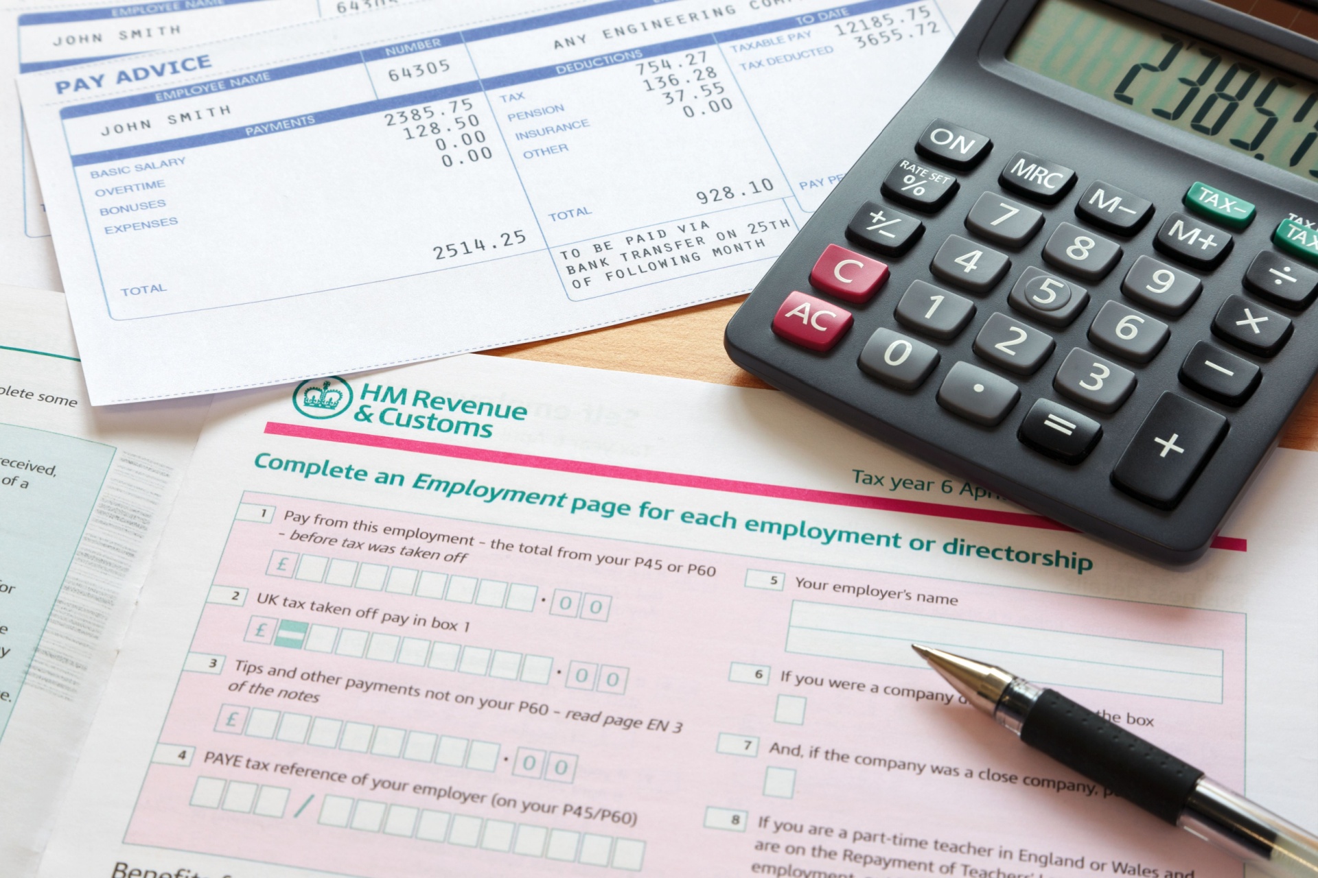 Paperwork relating to a tax return, with calculator and pen lying on it