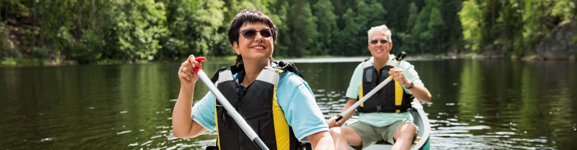A couple on holiday taking a canoe ride.