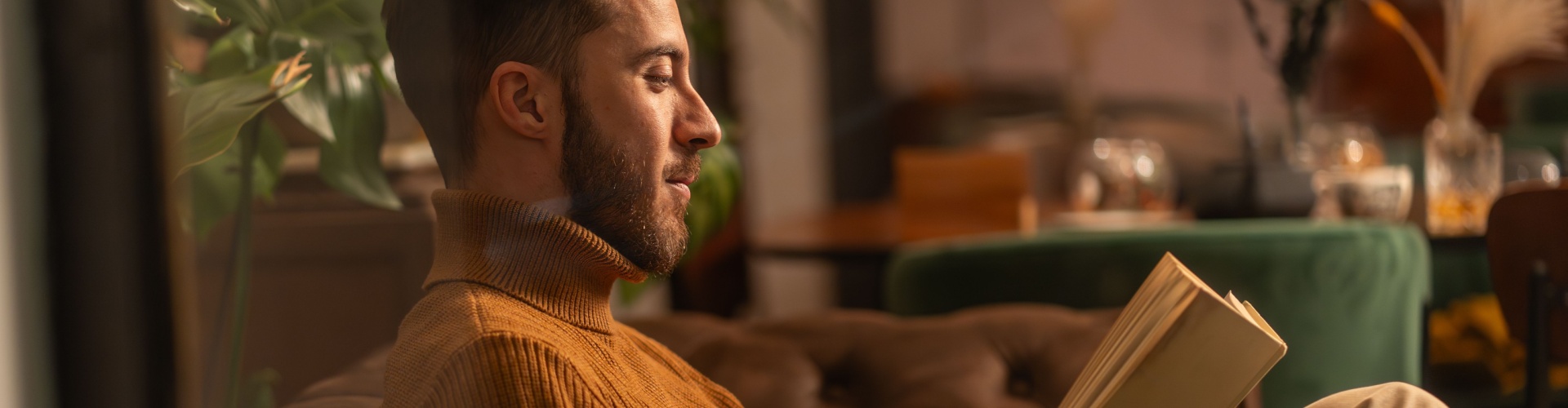 A man reading a book at home.