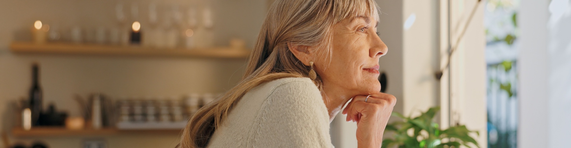A woman looking out of the window at home.