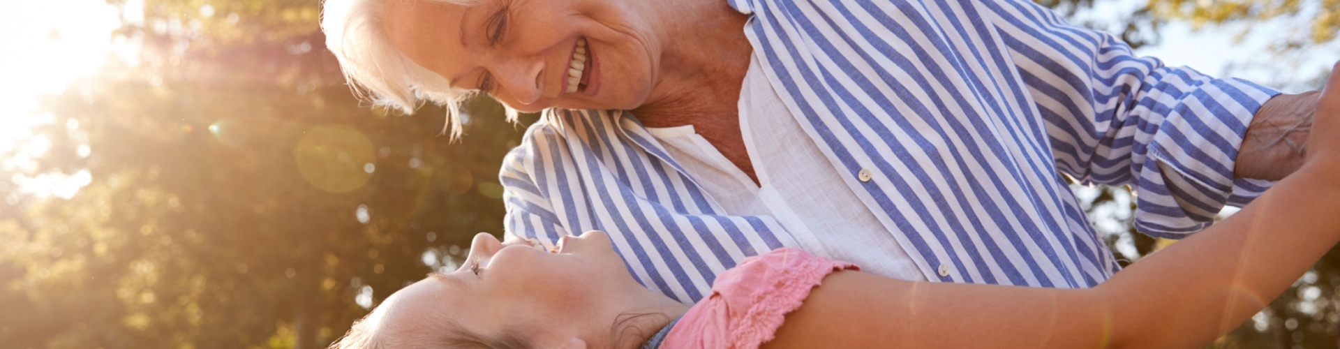 A grandmother playing with her granddaughter outside.
