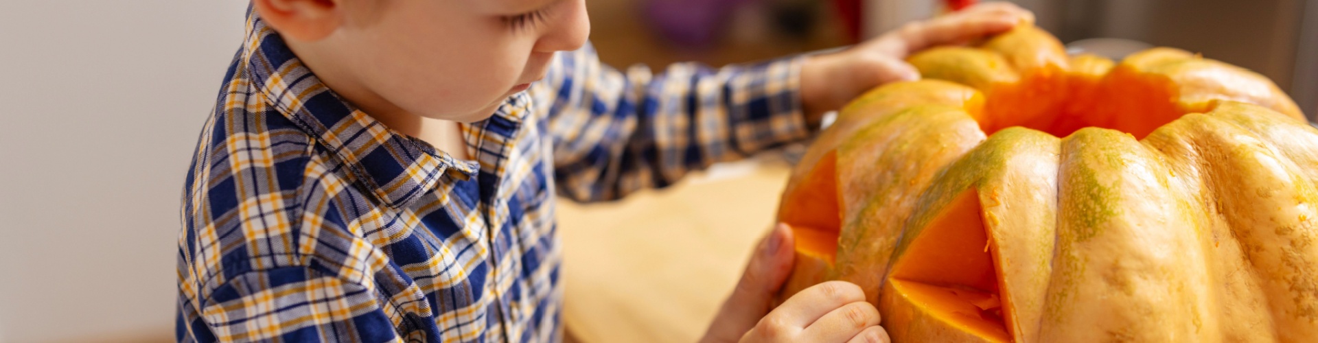 A child carving a pumpkin.