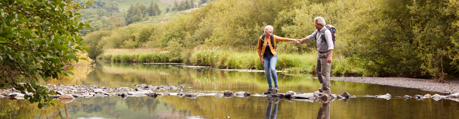 A couple walking across stepping stones.
