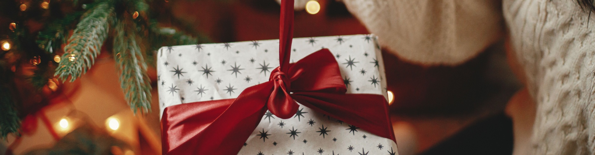 A woman untying a ribbon on a Christmas present.
