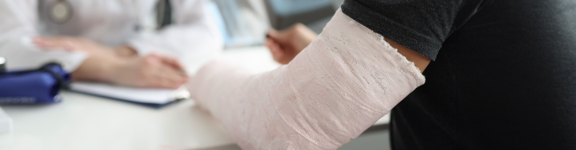 A man with a broken arm speaking with a doctor.