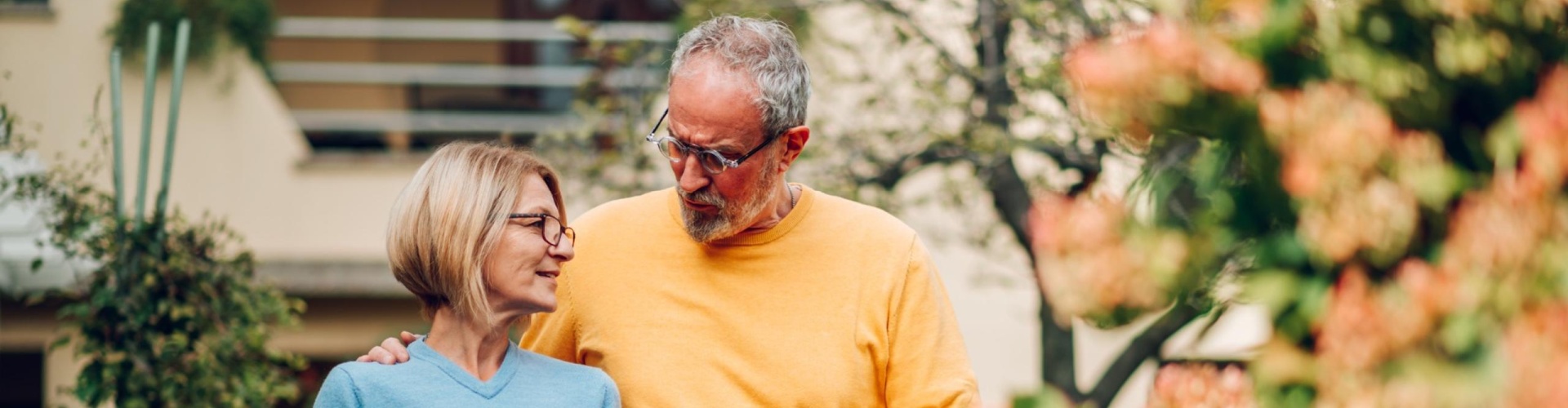 Mature couple walking outside a house