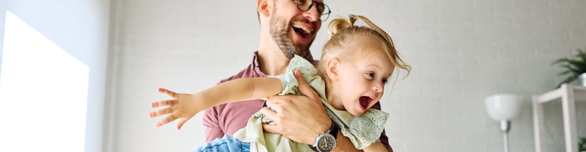 A father playing with his young daughter.